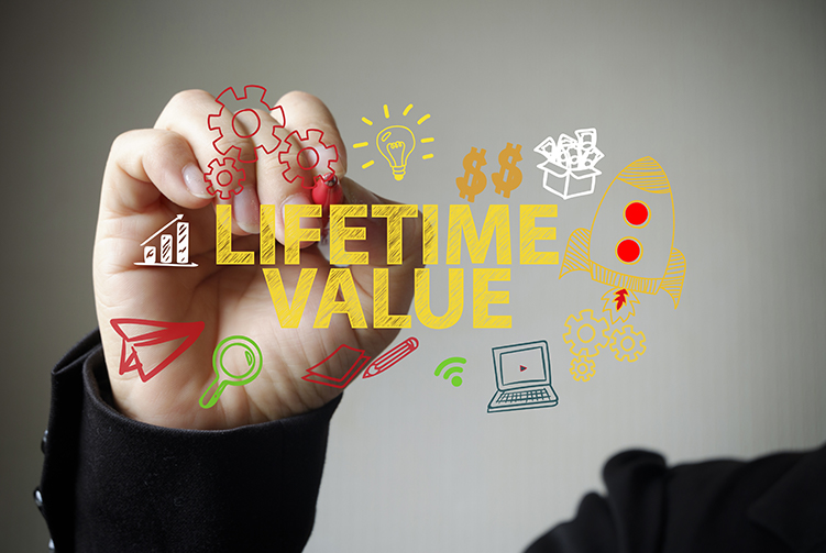 Hand holding pen overlaid by Lifetime Value graphic