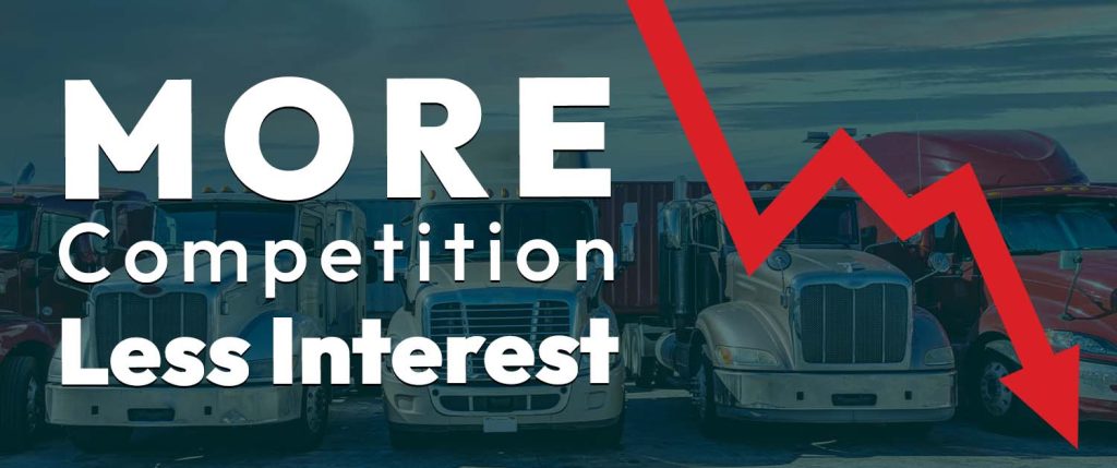 Banner with row of semi-trucks and large white text reading 'MORE Competition Less Interest' plus a red downward arrow, signaling declining interest or trend.
