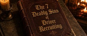 deadly sins article - Randall Reilly - Randall Reilly Leather-bound book titled 'The 7 Deadly Sins of Driver Recruiting' on a stone table beside a lit candle, in warm amber light.